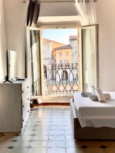 - une chambre avec un lit et une grande fenêtre dans l'établissement Lungarno Suite, à Pise