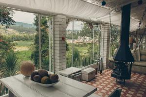 un bol de fruits sur une table devant une grande fenêtre dans l'établissement Cabaña típica Boyacense! con vista al lago y chimenea, à Paipa 25 autres photos