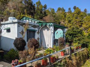 a small house with plants in a garden at Manu home stay in Almora