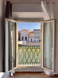 une fenêtre ouverte avec vue sur un bâtiment dans l'établissement Lungarno Suite, à Pise