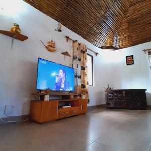 uma sala de estar com uma televisão de ecrã plano num centro de entretenimento em madeira em Manuastro Breeze Villa - Diani Beach em Galu