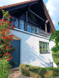 ein weißes Gebäude mit einem Balkon und roten Blumen in der Unterkunft Ferienwohnung In Bestform in Merkendorf