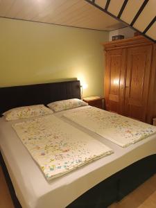 ein Bett mit einer Bettdecke und Blumen darauf in der Unterkunft Ferienwohnung In Bestform in Merkendorf