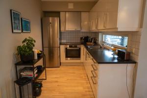 a kitchen with white cabinets and a black counter top at Leilighet Damsgård , nær sentrum in Bergen