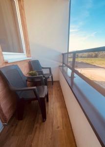einen Balkon mit 2 Stühlen und einem Fenster in der Unterkunft Apartmani borova 2 in Veliko Gradište