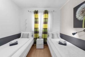 - 2 lits dans une chambre dotée de rideaux jaunes et verts dans l'établissement Holiday Homes in Porec - Istrien 42537, à Poreč