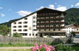 um grande edifício branco com uma cerca em frente em Hotel Arlberg em Sankt Anton am Arlberg