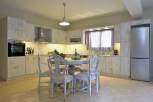 a kitchen with a table and chairs and a refrigerator at Villa Gaia in Dassia