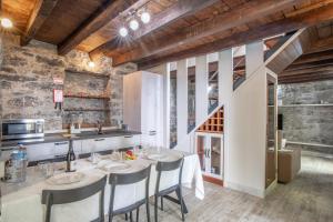 a kitchen with a table with chairs and a sink at Madeirense Villa in Santa Cruz in Santa Cruz