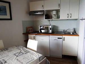 a small kitchen with white cabinets and a sink at Paradiski ski au pied vallandry in Landry