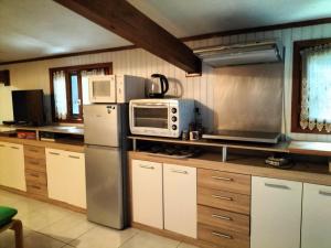 a kitchen with a refrigerator and a microwave at Gîte chez Kaky in Onesse-et-Laharie