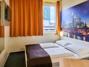 Habitación de hotel con cama y ventana en B&B HOTEL Frankfurt-Hbf, en Frankfurt