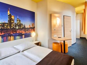 フランクフルト・アム・マインにあるB&B HOTEL Frankfurt-Hbfのベッドとデスクが備わるホテルルームです。