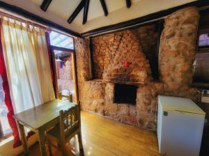 a stone room with a table and a fireplace at Logde Casa de campo & Retreat Center in Urubamba