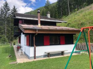 a house with red doors and a bench in front of it at Chalet avec vue imprenable et au calme in Chalais