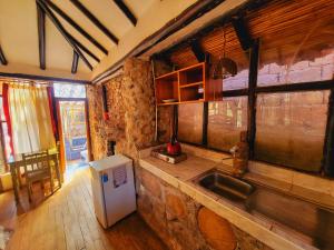 a kitchen with a sink and a stone wall at Casa de campo Yoga Retreat in Urubamba