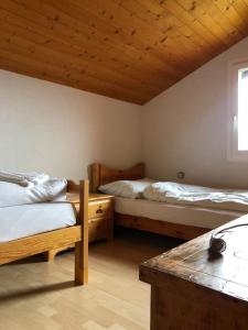 ChalaisにあるChalet avec vue imprenable et au calmeの木製の天井が特徴のベッドルーム1室(ベッド2台付)