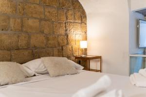 a bedroom with a bed and a stone wall at Santa Maria degli Angeli Apartment in Naples