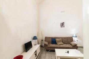 a living room with a couch and a tv at Santa Maria degli Angeli Apartment in Naples