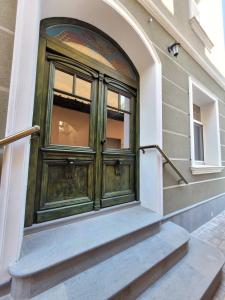een groene deur aan de zijkant van een gebouw bij The House - Central Boutique Apartments in Kyustendil
