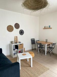 uma sala de estar com um sofá e uma mesa em La Baule, Plein Centre/Terrasse em La Baule