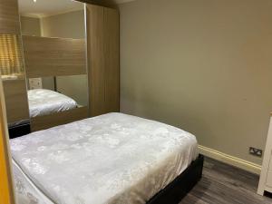 a small bedroom with a bed and a mirror at Ruislip Guest House in Ruislip