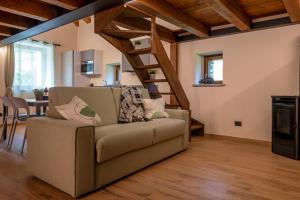 a living room with a couch and a staircase at Maison Marcoz - Appartamenti vacanze in Etroubles