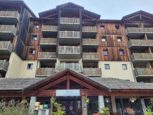 un immeuble avec balcon au-dessus d'un immeuble dans l'établissement Appart vue montagne Le Devoluy, à Saint-Étienne-en-Dévoluy