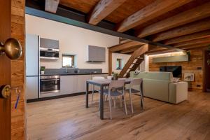 a kitchen and living room with a table and a couch at Maison Marcoz - Appartamenti vacanze in Etroubles