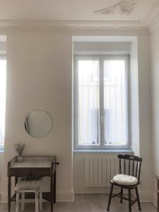Habitación con espejo, silla y ventana en Elegant, Spacious Apartment in Historic Center of Tournon, en Tournon-sur-Rhône