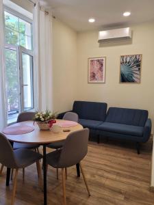 sala de estar con mesa y sofá en The House - Central Boutique Apartments, en Kyustendil