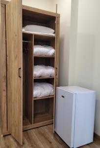 a room with a wooden closet with towels and a refrigerator at The House - Central Boutique Apartments in Kyustendil