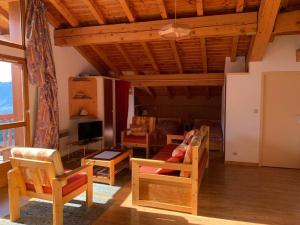 a living room with chairs and a couch and a tv at Paradiski proche vanoise express plan peisey in Peisey-Nancroix