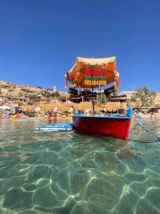 a boat sitting in the water near a beach at Duplex Casa uso esclusivo Wi-Fi e spiaggia vicino in Sharm El Sheikh