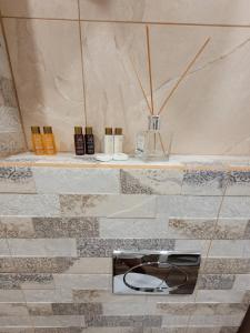 a bathroom with a shelf with cosmetics on it at The House - Central Boutique Apartments in Kyustendil