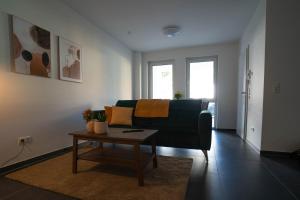 a living room with a couch and a coffee table at Modernes Ferienapartment: Komfort & Wohlfühlen in Fuldatal