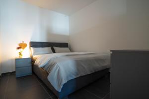 Modernes Ferienapartment: Komfort & Wohlfühlen في Fuldatal: غرفة نوم بسرير كبير وموقف ليلي