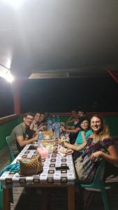 a group of people sitting around a table at Aloha Guest House Nias in Hilibotodane