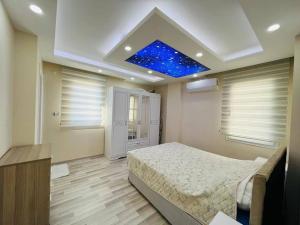 a bedroom with a bed and a blue ceiling at altınkum da denize 150 m 4+1 dublex in Didim