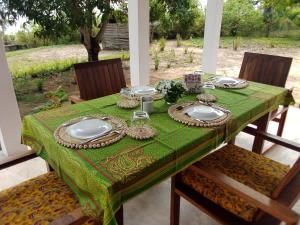 a table with a green table cloth and plates on it at Villa Moringa Lodge 