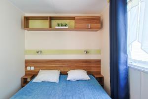 1 dormitorio pequeño con 1 cama azul y 2 almohadas en La vie est belle, en Angles