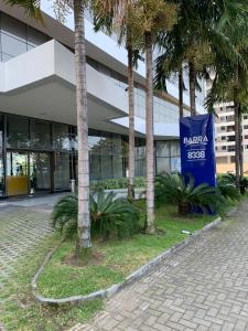 un bâtiment avec des palmiers en face de celui-ci dans l'établissement Flat a beira mar, à Récife