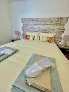 a bedroom with a bed with a headboard and ahat on it at APART Casas Brancas in Vila Viçosa