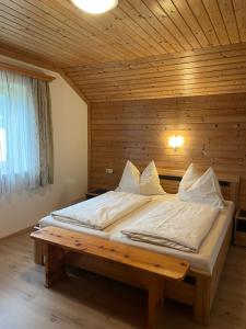 ein Schlafzimmer mit einem Bett in einem Holzzimmer in der Unterkunft Ferienwohnung Renate Hubner in Gosau