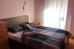 a bed in a bedroom with a dresser and a window at Wonderful apartment for Families and more in Rīga
