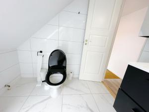 a bathroom with a toilet with a black seat at Aalborg city center newly renovated house in Aalborg