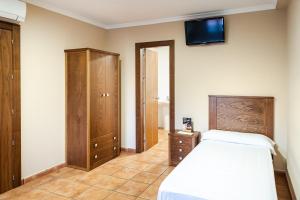 a bedroom with a bed and a tv on the wall at AS HOTELES FUENTE LA HIGUERA direccion Albacete in Fuente la Higuera