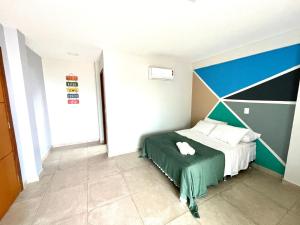 a bedroom with a bed with a green and blue wall at APARTAMENTO SOPHIA I - ORLA da PRAIA GRANDE in Arraial do Cabo