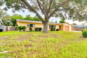 una casa con un árbol en un patio en Sunny Seminole Retreat with Patio, Near Beaches!, en Redington Shores