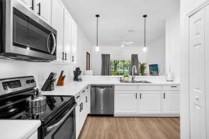 uma cozinha com armários brancos e um forno com placa de fogão em Bahama Bay, Davenport, Florida Oversize 2 Br condo em Kissimmee